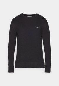 Maglione nero a maglia con maniche lunghe, scollatura rotonda e polsini a coste. Presenta un piccolo logo sulla parte anteriore.