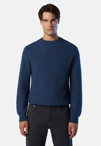 Suéter de punto azul marino con cuello redondo y mangas largas, que presenta un patrón texturizado y puños de canalé. Combinado con pantalones oscuros.