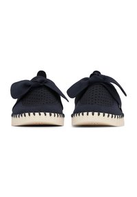 Par de zapatos sin cordones azul marino con partes superiores perforadas, lazos de tela decorativos y suelas cosidas de color crema, mostrados desde el frente.