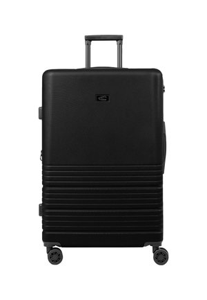 Valise noire rigide avec des rainures horizontales, poignée télescopique et quatre roues pivotantes. Présente un petit logo à l'avant.