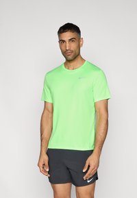 Κοντομάνικο αθλητικό μπλουζάκι Nike σε νέον πράσινο χρώμα με στρογγυλή λαιμόκοψη. Διαθέτει διακριτικό γκρι λογότυπο Swoosh στο αριστερό μέρος του στήθους.