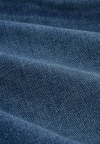 Denim-kangas syvässä sinisessä värissä, jossa on teksturoitu kudos, esittelee hienovaraisia vaihteluita ja sileää laskeutumista.