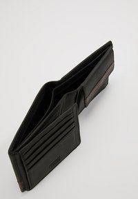 Portefeuille en cuir noir avec plusieurs emplacements pour cartes et un compartiment. Il présente une finition texturée et des coutures contrastées.