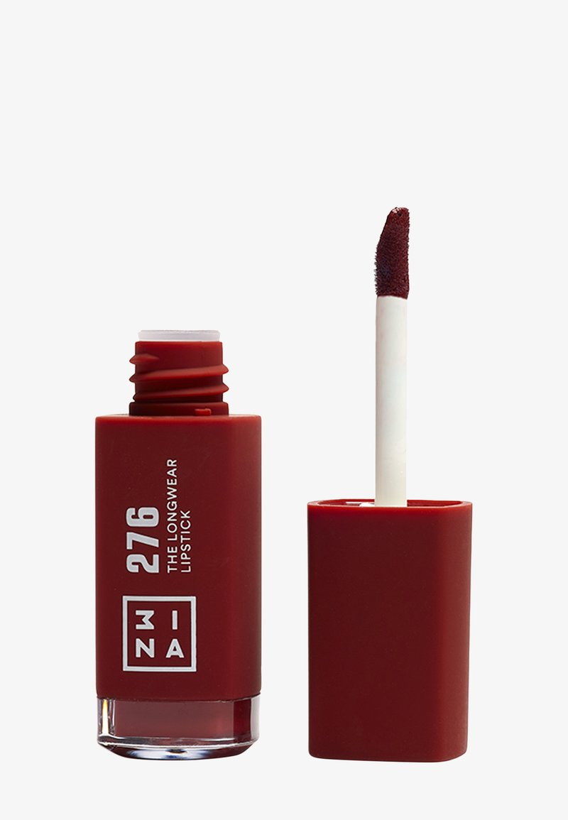 Lápiz labial de larga duración en un envase rojo mate con marca blanca. El aplicador es blanco con punta en forma de cúpula para una aplicación precisa.