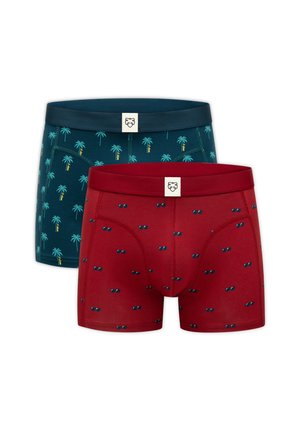 Due paia di boxer, uno rosso con piccoli motivi di occhiali da sole, uno verde acqua scuro con motivi di palme, entrambi con elastici in vita di colore uniforme.