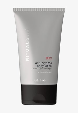 Rituals Sport Anti-Trockenheit Körperlotion mit Aktivkohle in einer 100 ml grauen Tube mit schwarzem Deckel.