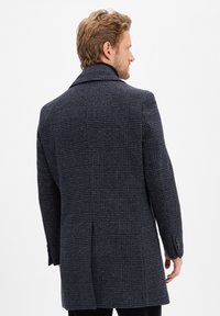 Dunkelblauer Gehrock mit Karomuster, Reverskragen und einfacher Rückenbelüftung. Das Material scheint aus strukturiertem Wolle mit Knopfdetails zu bestehen.