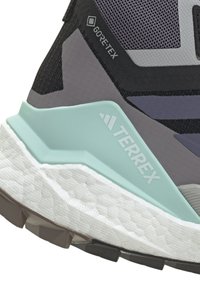 GORE-TEX turistsko sko i grått og svart, med en strukturert mesh-overdel, lyse mintfarger i akcent og en robust, mønstret såle.