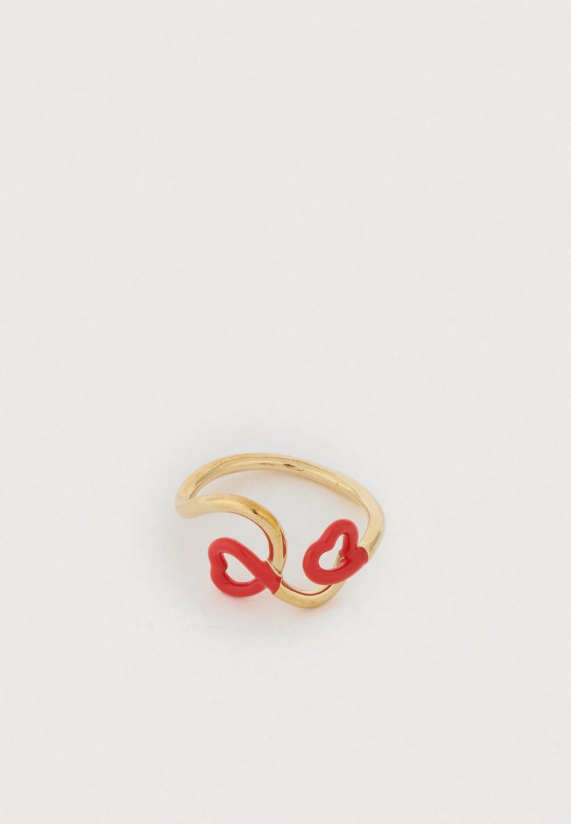 Χρυσό δαχτυλίδι με στριφτό σχέδιο και δύο κόκκιν�α σχήματα καρδιάς στα άκρα. Λεπτό φινίρισμα με αντιθετικά χρώματα.