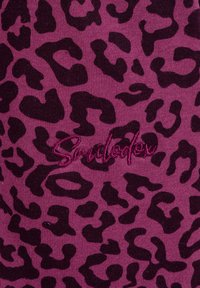 Macchie di leopardo viola scuro su un tessuto magenta lavorato a maglia con testo corsivo ricamato magenta al centro.