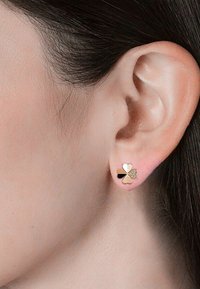 Goudkleurige oorbellen met een ontwerp van een klavertje vier, versierd met harten in roze, zwart en heldere kristallen accenten, bevestigd aan een stekker.