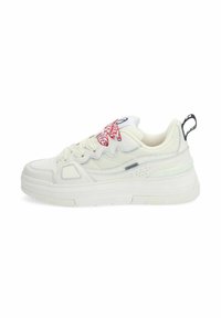 Baskets blanches en cuir texturé et en maille, avec une semelle épaisse, un motif en zigzag rouge sur la languette et un onglet de talon noir.