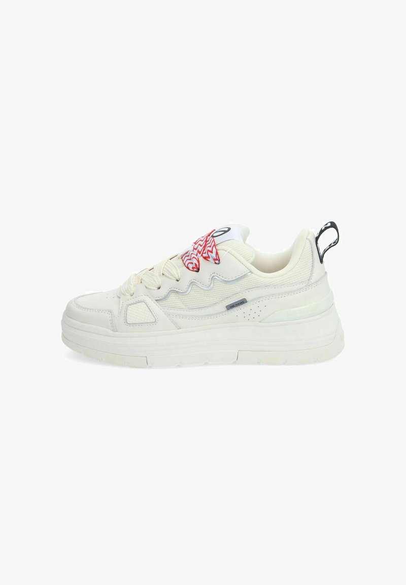 White sneaker with textured leather and mesh, featuring a chunky sole, red zigzag pattern on the tongue, and a black heel tab.