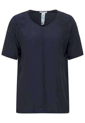 Blouse bleu marine à manches courtes avec un col en V, fabriquée en tissu lisse. Présente des plis subtils sur les épaules, coupe décontractée sans motifs.