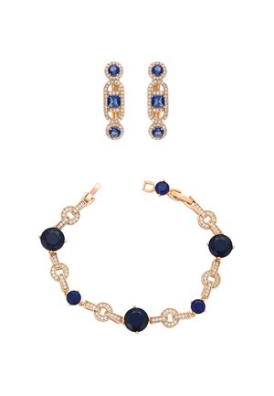 Set di gioielli in tono oro con bracciale adornato da pietre navy e cristalli trasparenti, e orecchini coordinati con design ovale e rotondo.