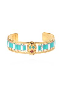 Bracelet en plaqué or avec des perles turquoise et blanches, un centre en masque détaillé avec des accents en pierre rouge, et un design de perles complexe.
