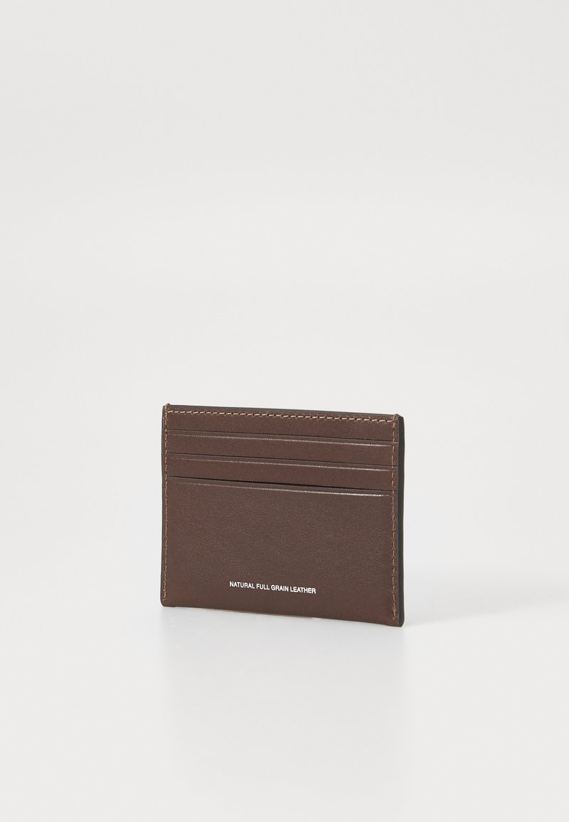 Brown leather card case with multiple slots, featuring a smooth texture and subtle stitching. "NATURAL FULL GRAIN LEATHER" printed on front.