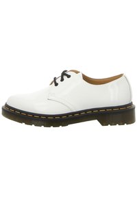 Chaussure Oxford en cuir verni blanc avec lacets noirs, semelle extérieure translucide épaisse et couture jaune autour du bord de la semelle.
