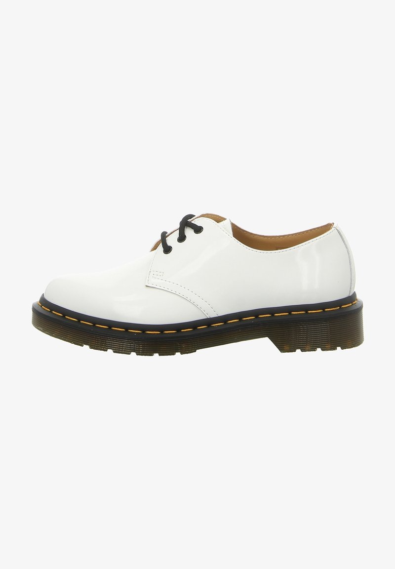Chaussure Oxford en cuir verni blanc avec lacets noirs, semelle extérieure translucide épaisse et couture jaune autour du bord de la semelle.