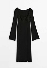 Robe noire côtelée avec de longues manches évasées, décolleté carré et silhouette ajustée, présentant un détail nœud au niveau de la poitrine.
