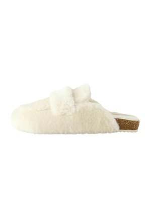 Faux fur slippers in cream, featuring a cushioned interior, open back, and brown textured outsole. Simple design with no visible hardware.