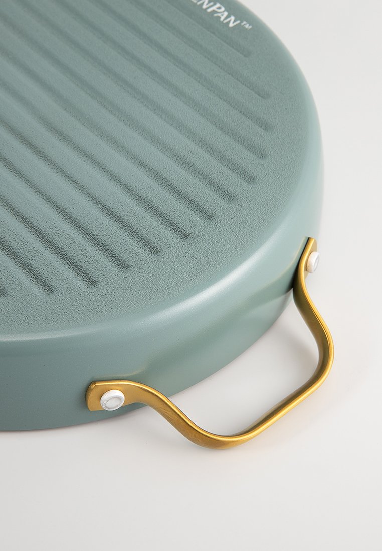 Poêle à griller ronde, turquoise, avec une surface striée, un manche doré et des bords lisses. Caractéristiques d'une conception robuste pour la cuisson et la manipulation.