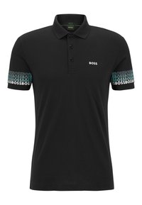 Polo noir en coton, avec une patte de boutonnage à trois boutons, des accents verts et le logo "BOSS" en blanc et bleu clair sur les manches.
