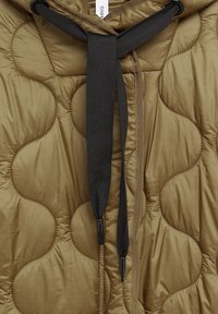 Olivengrøn dunjakke med quiltede, afrundede sektioner, med sort snørelukning og glat, skinnende stoftekstur.