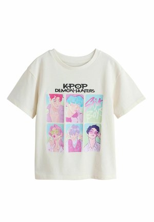 Hvid bomulds-T-shirt med et grafisk tryk af seks illustrerede figurer i levende farver, med teksten "KPOP DEMON HUNTERS" øverst.