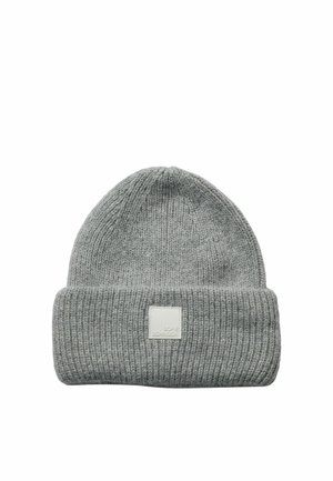 Bonnet tricoté gris clair avec bord roulé et une petite étiquette rectangulaire blanche à l'avant.