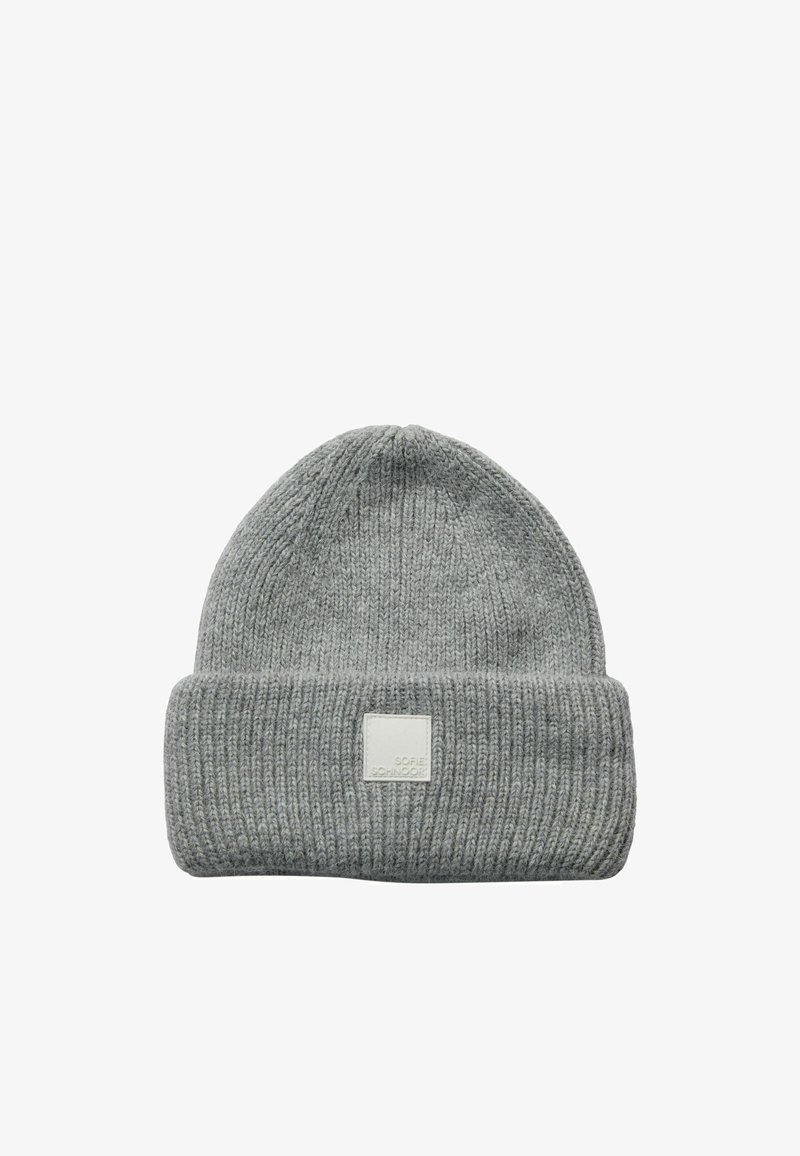 Bonnet tricoté gris clair avec bord roulé et une petite étiquette rectangulaire blanche à l'avant.