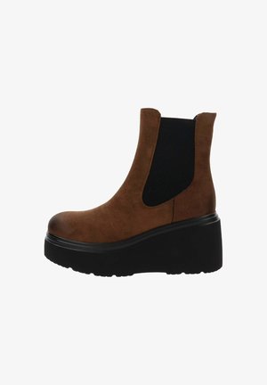 Stivale alla caviglia in suede marrone con pannelli laterali elastici neri, punta arrotondata e suola piattaforma nera spessa per un'altezza aggiuntiva.