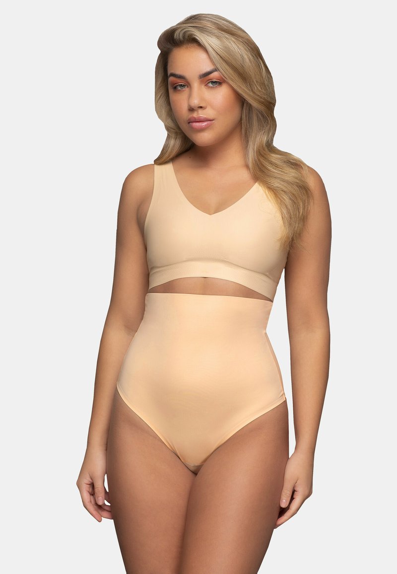 Un sous-vêtement nude avec un design en V, une construction sans coutures, et un bas taille haute avec une découpe au niveau du ventre pour un ajustement lisse.