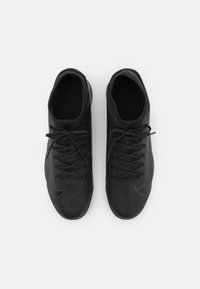 Sorte sportsko med en struktureret overdel, glat snørredetalje og et kontrasterende blåt swoosh-motiv. Elegant design med afrundet tå.