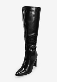 Bota negra hasta la rodilla hecha de cuero brillante, con puntera puntiaguda y un tacón ancho, todo con un diseño liso y sin costuras.