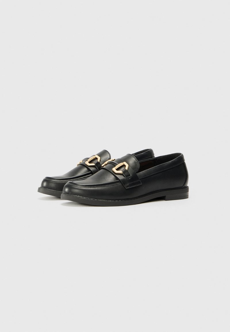 Mocasines de cuero negro con un acabado suave, que cuentan con herrajes en tono dorado y un tacón bajo para mayor estabilidad. Diseño clásico.