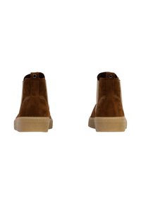 Bottines en suède marron avec une semelle en caoutchouc texturée, bout rond et détails de couture ; comprend un tirant à l'arrière.
