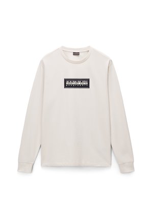 T-shirt beige a maniche lunghe realizzato in cotone. Presenta un logo rettangolare nero con testo bianco sul petto. Scollo rotondo semplice e polsini a costine.