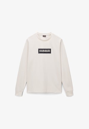 T-shirt beige a maniche lunghe realizzato in cotone. Presenta un logo rettangolare nero con testo bianco sul petto. Scollo rotondo semplice e polsini a costine.