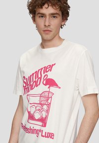 Camiseta blanca de algodón con un atrevido diseño gráfico en rosa que presenta una bebida con hielo, un flamenco y el texto "Estado de verano y refrescante de lujo."