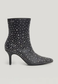 Zwarte leren enkellaars met puntige neus, stiletto-hak en verspreide zilveren studs als versiering over het oppervlak.