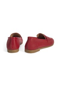 Rote Leder-Slipper haben ein strukturiertes Finish, ein niedriges Profil und ein weiches Futter mit einer flachen Gummisohle. Akzentuiert mit einem minimalistischen Design.