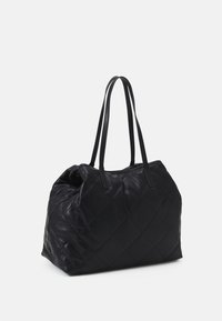 Czarna pikowana torba shopper z dwoma długimi uchwytami, o zaokrąglonym kształcie i subtelnym połysku. Posiada usztywnioną podstawę i górne otwarcie.