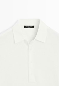 White textured polo shirt with folded collar and three buttons, featuring a "Massimo Dutti" brand label inside the collar.