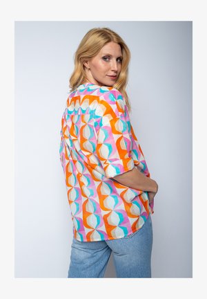 Bunt gemustertes kurzärmeliges Hemd mit einem geometrischen Muster in Orange, Pink und Türkis auf hellen Hintergrund, aus leichtem Stoff gefertigt.