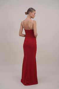 Rdeča, prilegajoča večerna obleka z elegantnim dizajnom, izrezom na hrbtu in trakovi, okrašenimi s biseri. Gladka tekstura, dolga do tal s subtilnim vlakom.