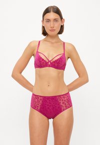 Fuchsia bh en hoogwaist slip set gemaakt van doorzichtig kant met een luipaardprintpatroon. Voorzien van verstelbare bandjes en decoratieve naden.