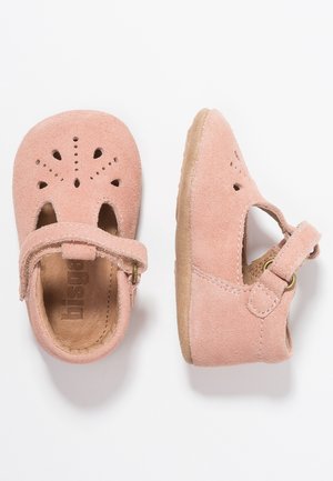 Chaussures bébé en daim rose avec embout arrondi, design perforé et bride à boucle. Dotées d'une semelle intérieure en cuir souple et d'une semelle en caoutchouc.
