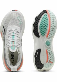 Zapatillas de correr blancas con parte superior de malla, acentos turquesas, detalles en negro y suela texturizada que combina goma y espuma.
