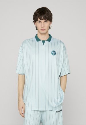 Lyseblå kortærmet polo med lodrette striber, grøn krave og logo på venstre bryst. Blødt, glat stof med en afslappet pasform.